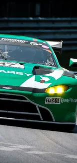 Green racing car speeding on a track in daylight.