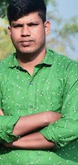 Man in green shirt against a vibrant outdoor background.