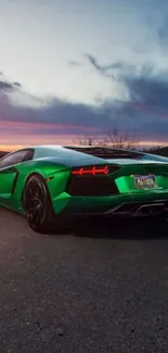 Green sports car on a road at sunset with colorful sky.