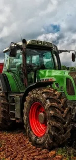 Green tractor standing in a rustic farm field with a cloudy sky.