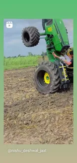 Green tractor performing a wheelie on a rural farm field.