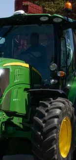 Green tractor on farmland with clear sky.