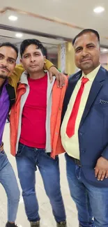 Group of three friends posing indoors in colorful outfits.