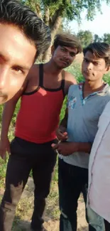 Group selfie in a sunlit outdoor field with trees.