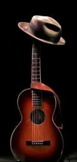 Classic guitar with a hat atop on dark background.