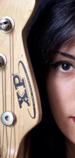 Guitar neck and woman's half face with bold makeup.