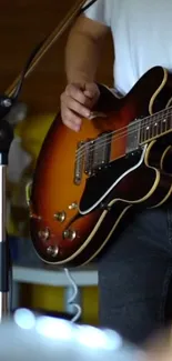 Close-up of a guitarist playing electric guitar on a casual stage setting.