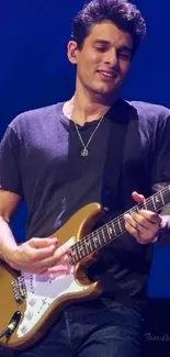 Guitarist performing on stage with electric guitar and blue lighting.