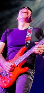 Man playing electric guitar on stage with vibrant lighting.