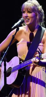 A musician plays guitar on stage with vibrant lighting.