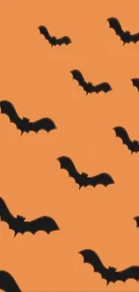 Orange background with black bat silhouettes for Halloween wallpaper.