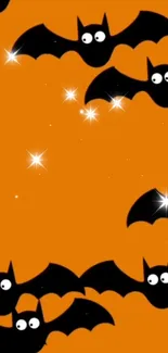 Halloween themed wallpaper with black bats on an orange background.