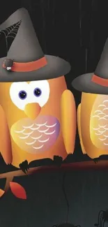 Halloween wallpaper with two owls wearing witch hats on a branch.