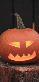 Carved pumpkin glowing on a wooden stump, perfect for Halloween.