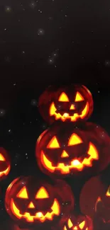 Glow of Halloween jack-o'-lanterns against a starry night sky.