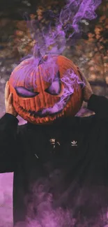 Person wearing pumpkin head with purple smoke in a spooky forest.