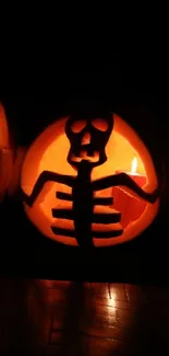 Glowing skeleton carving on Halloween pumpkin in the dark.