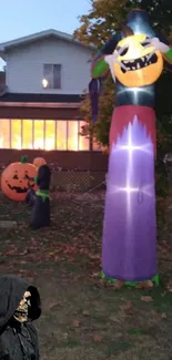 Halloween yard decorations with inflatable pumpkins and spooky figures in the evening.