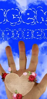 Hand holding heart in blue cloudy sky with floral designs.