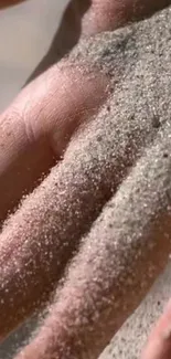 Close-up of a hand covered with sand, showing texture.