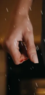 Close-up of a hand with a raindrop effect, creating a calming wallpaper.