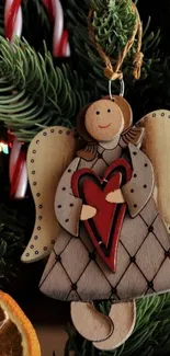 Wooden angel with red heart on Christmas tree.