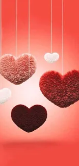 Fluffy red and white hearts hanging against a warm red background.