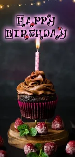 Happy birthday cupcake with pink candle on a dark background.