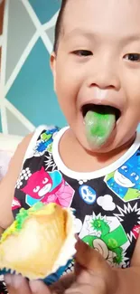 Child with green tongue eating a colorful snack.