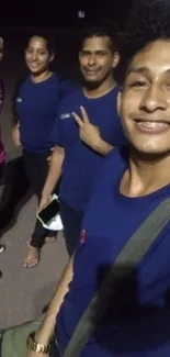 Group of friends taking a joyful night selfie on the street.