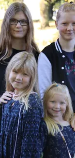 Outdoor photo of four smiling girls with a green nature background.