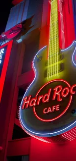 Neon guitar sign at Hard Rock Cafe with bold, vibrant colors.