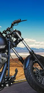 Harley Davidson motorcycle on desert road under blue sky.