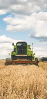 Combine harvester in a golden wheat field under a cloudy sky.