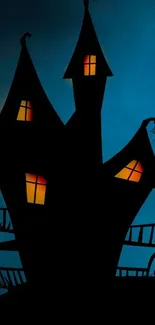 Haunted house silhouette on dark blue night sky.