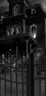 A black-and-white image of a haunted Gothic manor behind a fence.