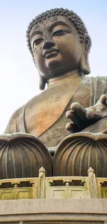 Majestic bronze Buddha statue under a clear sky.