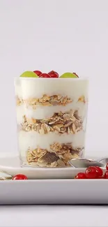 Glass of yogurt parfait with granola and berries on white background.