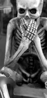 Three skeleton statues in 'see no evil' poses, black and white design.