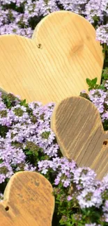 Wooden hearts on a bed of purple flowers.