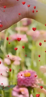 Hand over flowers with floating red hearts.