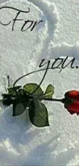 A red rose on a heart shape drawn in the snow with 'For you' text.