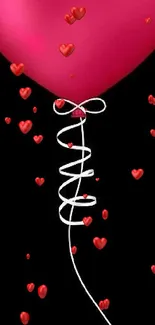 Pink heart-shaped balloon on black background wallpaper.