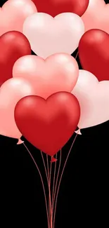 Heart-shaped balloons in red and pink floating against a black background.