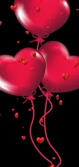 Three glossy red heart-shaped balloons on black.