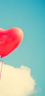 Heart-shaped red balloon floats against a blue sky in this mobile wallpaper.