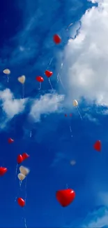 Heart-shaped balloons drifting in a vibrant blue sky with clouds.