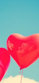 Red heart balloons float in clear blue sky.