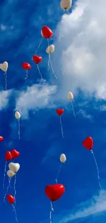 Heart-shaped balloons float against a vivid blue sky with scattered clouds.