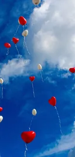 Heart-shaped balloons float in a blue sky.